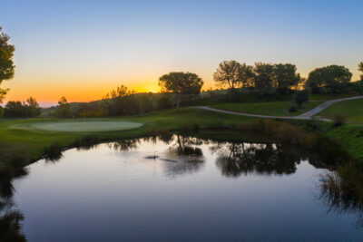 Hole with a lake and trees around at sunset