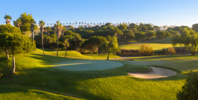Hole with bunker next to it and trees all around, at Castro Marim Golf Course