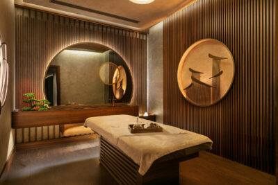 Spa treatment room with a modern decor, and a treatment bed in the middle of the room ready for the ultimate relaxing experience