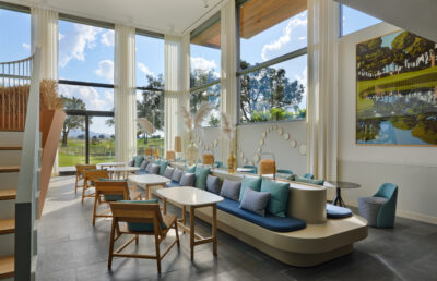 Indoor seating area with blue accents and windows looking out on to the golf course