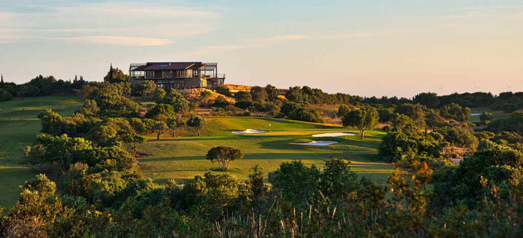Aerial biew of golf course with building in distance at Espiche