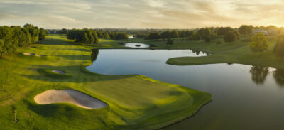Large lake on fairway with trees around at sunset
