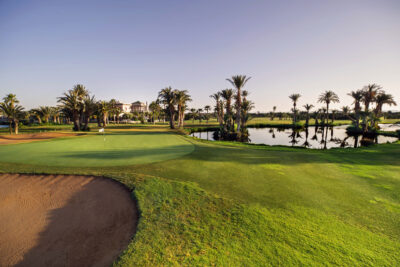 Greenside surrounded by lake on the right and a bunker at the front of the green at Golf Club Palmeraie