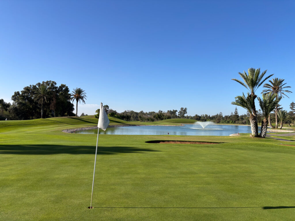 Green with lake and water fountain in background at Golf du Soleil