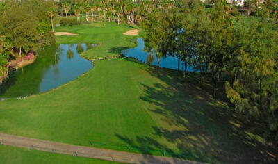 Aerial view of the fairway at Golf Las Americas with lake and trees around