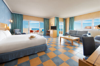 Hotel Elba Sara bedroom with a lounge area