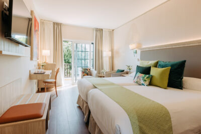 Double bed accommodation with seating area and doors leading to private patio