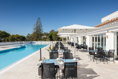 Outdoor seating next to the outdoor pool at Hotel Dona Filipa