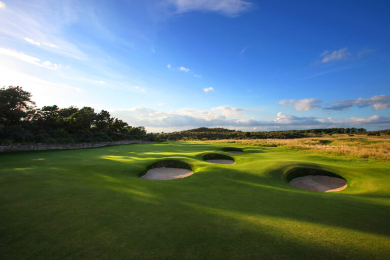 Hole with bunkers at Muirfield with trees in background