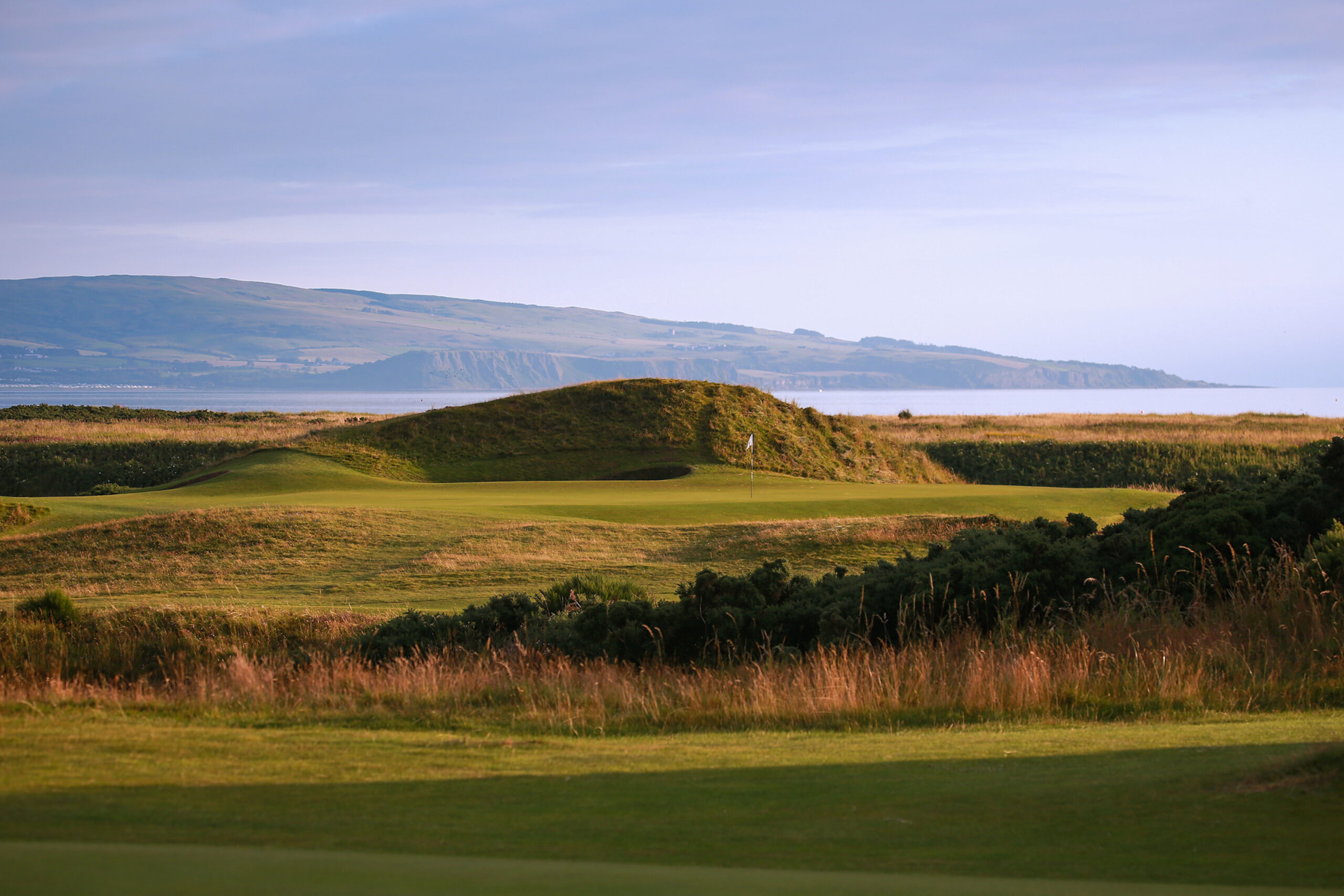 Hole with white flag and mounds around at Royal Troon - Old Course