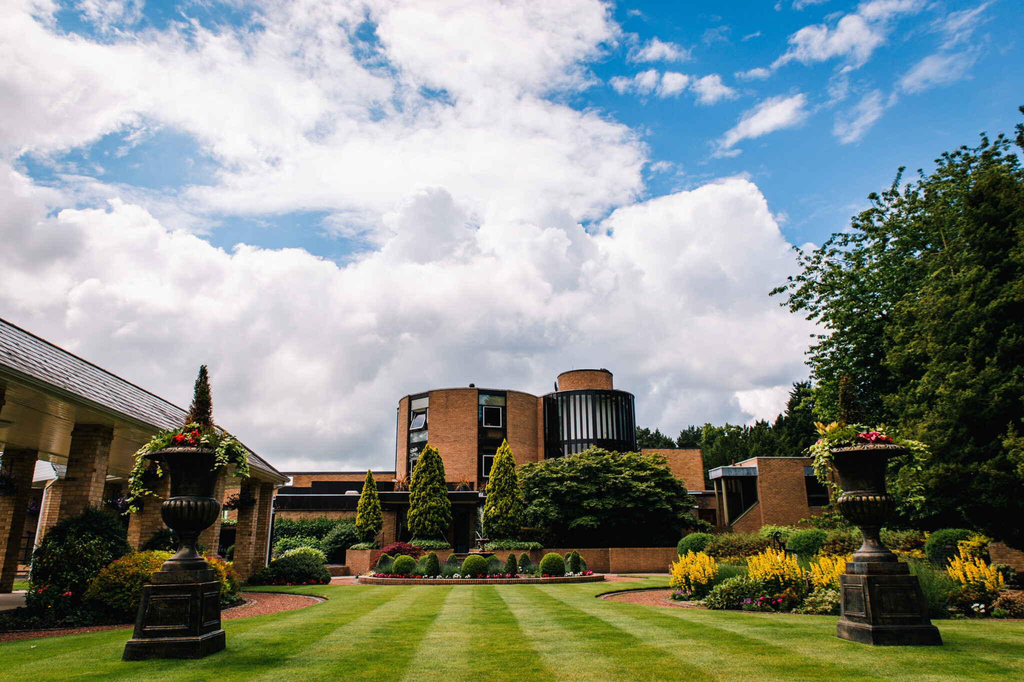 Exterior of Macdonald Portal Hotel with view of the gardens with trees and flowers