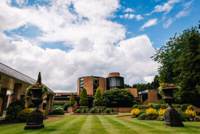 Exterior of Macdonald Portal Hotel with view of the gardens with trees and flowers