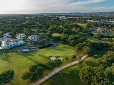 Aerial view of Vila Sol Golf Course with trees and buildings around