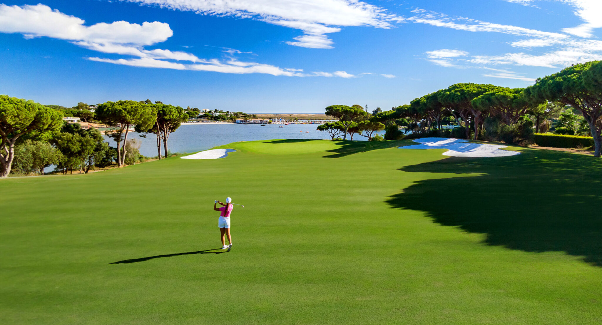 Woman playing golf at Quinta Do Lago South Golf Course with a lake in the background