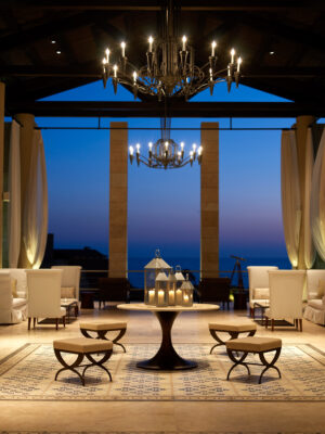 Lobby area at The Romanos Resort with white chairs and candles around