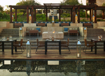 Outdoor seating and dining area with trees in the background