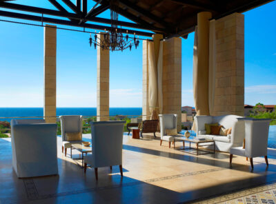 Seating area with beach view at The Romanos Resort, with white chairs