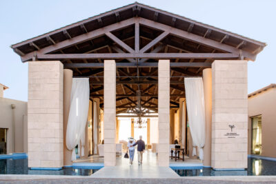 Entrance to The Romanos Resort with people walking through
