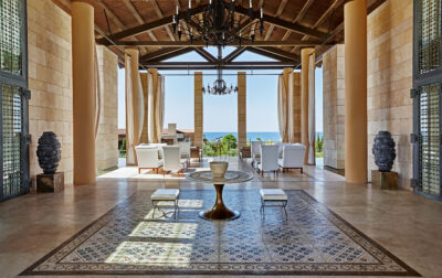 Lobby area at The Romanos Resort with a seating area with white chairs