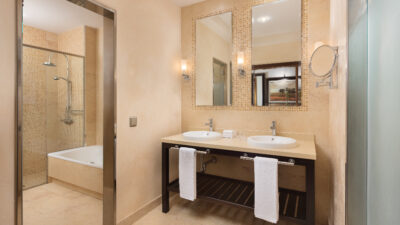Accommodation bathroom with his and hers sinks and a seperate bath/shower area