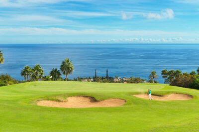 Person playing golf at Tecina Golf with ocean view