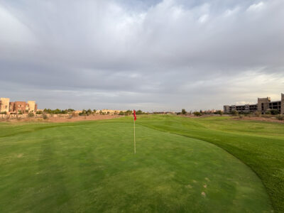Greenside with backdrop of surrounding apartments at The Montgomerie Marrakech
