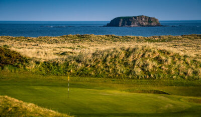 Hole with bunker and ocean in background at Ballyliffin Golf Club - Glashedy Course