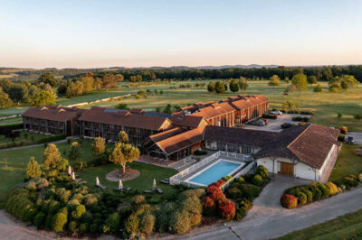 Aerial view of Chateau des Vigiers with trees around and an outdoor pool