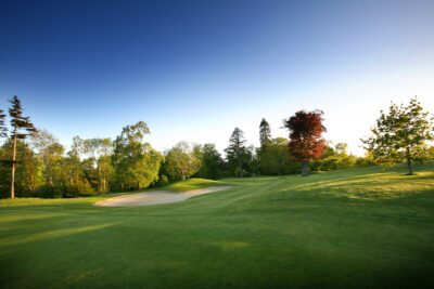 Bunker on fairway at Druids Glen Golf Course with trees around