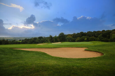 Hole with bunkers at Golf Saint Omer with trees in background