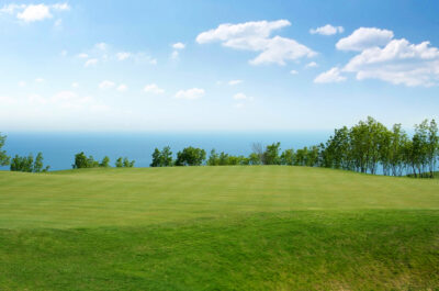 Fairway at Lighthouse Golf Course with trees around and a view of the ocean