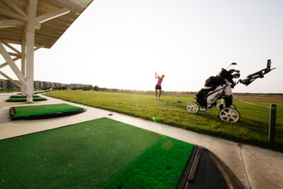 Driving range at Lighthouse Golf Course with buildings in the distance
