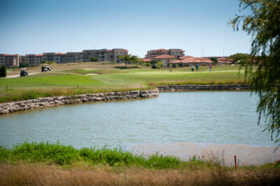 Lake on fairway with buildings in the distance at Lighthouse Golf Course