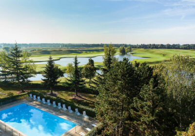Outdoor pool with a view of the golf course at Novotel Saint Quentin