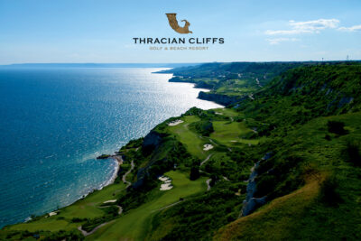 Aerial view of Thracian Cliffs Golf Course ocerlooking the ocean with a logo