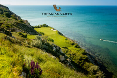 Aerial view of golf course on a clifftop overlooking the ocean with the Thracian Cliffs logo